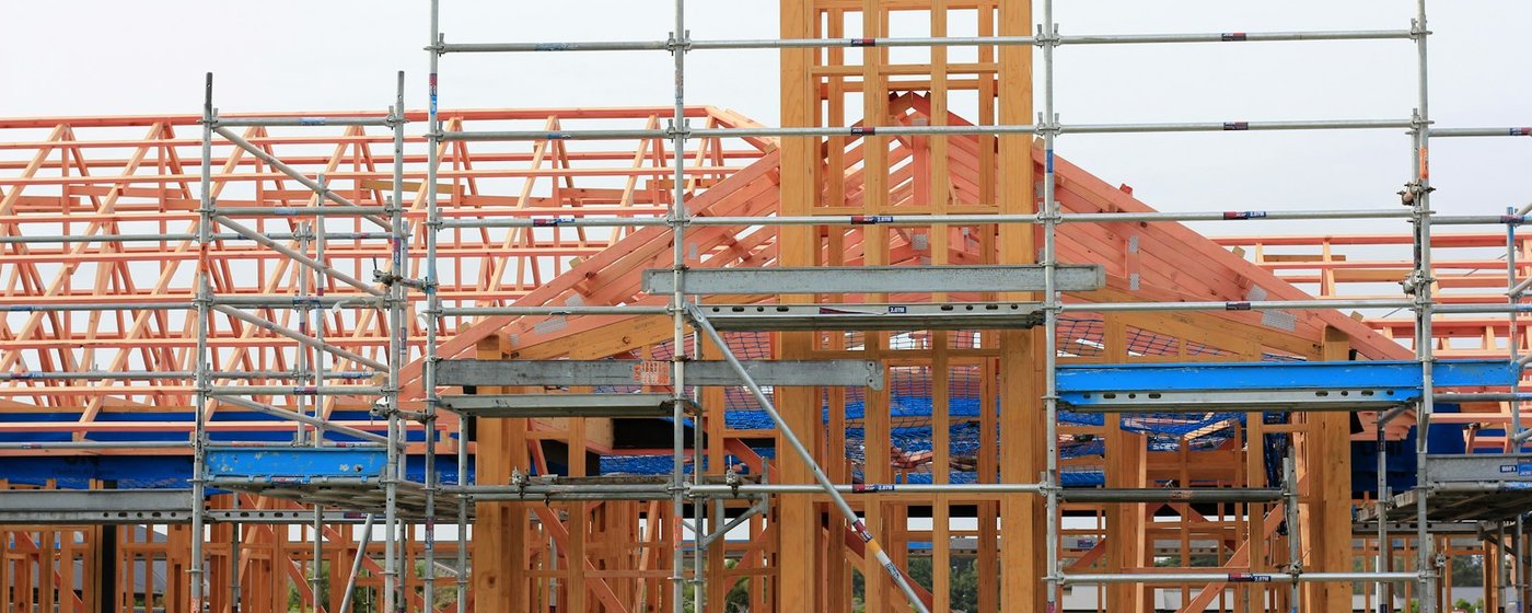 Timber house frame with scaffolding under construction
